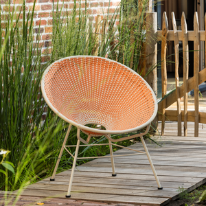 Fauteuil de jardin en rotin orange, photo d'ambiance